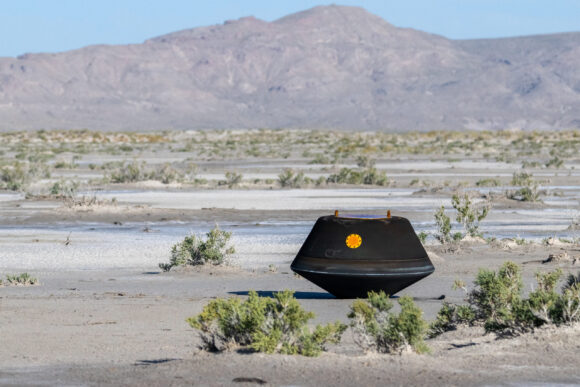 A black NASA orb-shaped capsule in the Utah desert during daytime.