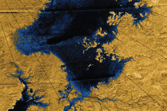 Radar image of a lake taken from high above Titan's surface shows liquid areas as dark blue and land areas as dark yellow.