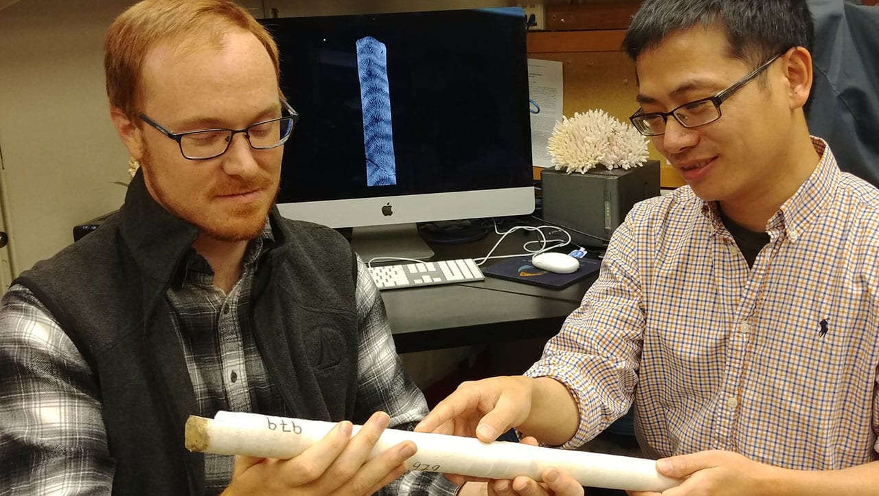 MIT-WHOI Joint Program student Nathaniel Mollica (left) and WHOI scientist Weifu Guo examine a core extracted from a coral skeleton. Photo by Anne Cohen Lab, ©Woods Hole Oceanographic Institution