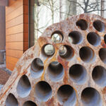 Sculpture by Julian Charriére: closeup of the pattern of core sample holes made in a large glacial erratic boulder installed outside of Building 55.