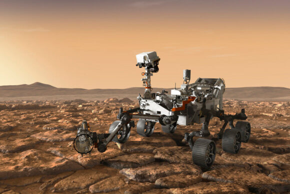 Rendering shows the Perseverance on the rocky brown surface of Mars. The Perseverance resembles a go-cart and has 6 wheels and an arm extending that houses the drill. The top of the Perseverance has a long neck and a camera on top.