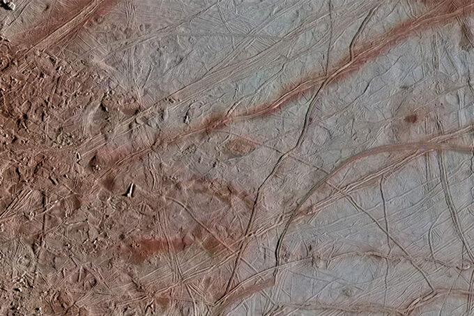 Image of chaos transition terrain on Europa. Sections of the ground look rocky and are scored through by tall ridges.