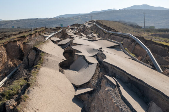 Roadway buckled by earthquake damage.
