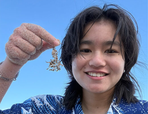 Isabella Yeung holding up a piece of ocean seagrass.