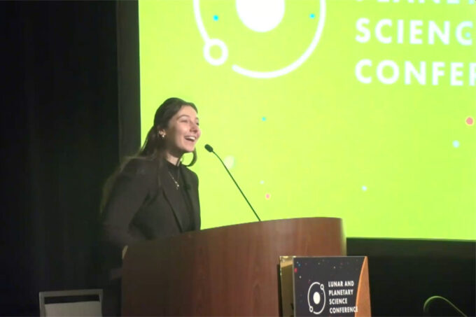Angelina Serafini giving a talk at a podium.