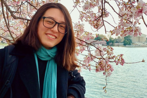 A photo of Sheila Baber in front of cherry blossoms in Washington, DC