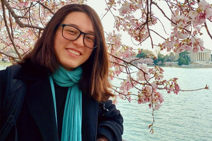 A photo of Sheila Baber in front of cherry blossoms in Washington, DC